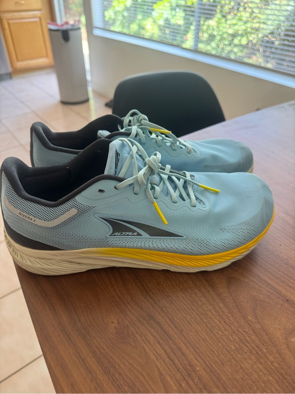 Altra light blue running shoes with yellow accents